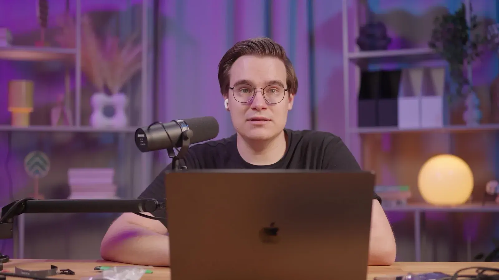 Studio solo: biurko z mikrofonem i laptopem w fioletowym świetle